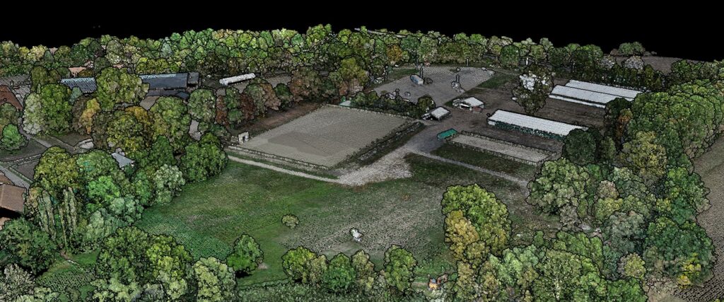 A photogrammetric point cloud of a farm built from drone photos: trees, buildings, greenhouses and an arena in 3D